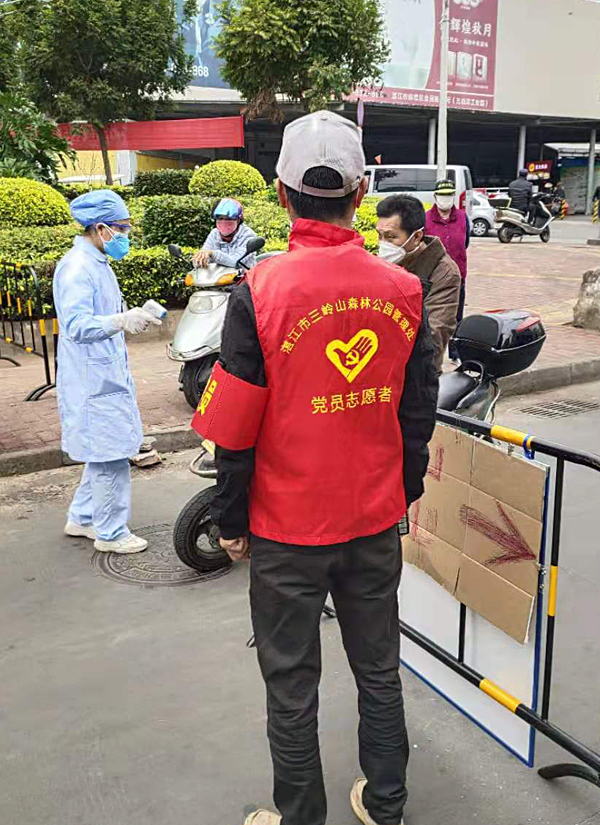 我局選派黨員協(xié)助醫(yī)務(wù)人員給過往路人測量體溫.jpg