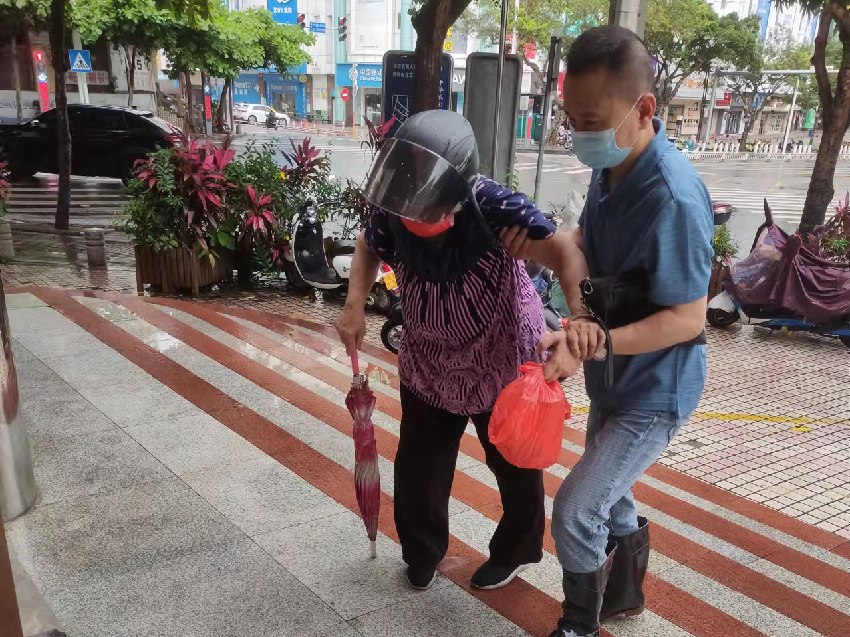 保障中心副主任葉學軍正攙扶腿腳不便的老人進入賓館安置.png