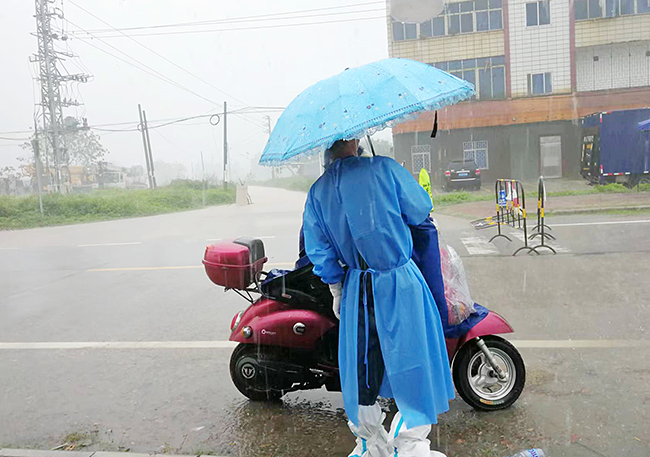 冒著大雨查驗過往路人的健康碼.jpg
